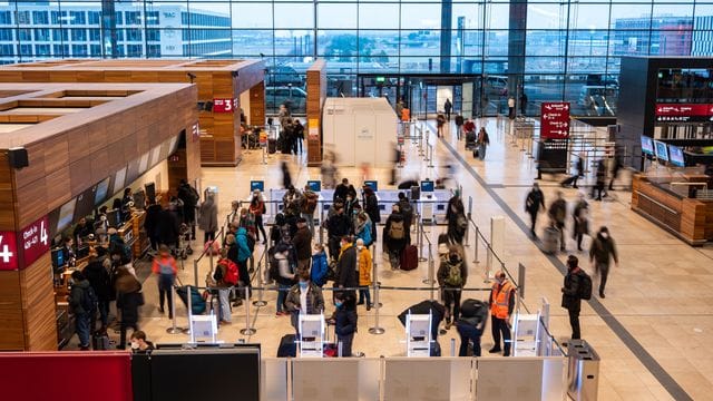 Passagiere stehen am Check-in-Schalter