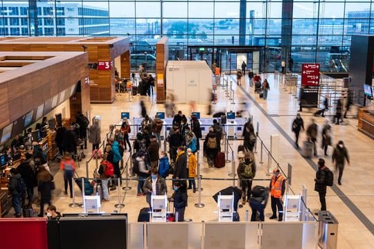 Passagiere stehen am Check-in-Schalter