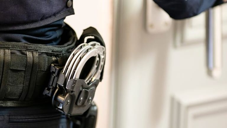 Handschellen sind an einem Gürtel eines Justizvollzugsbeamten befestigt (Symbolbild): Zwei Verdächtige sind von der Polizei durchsucht und festgenommen worden.