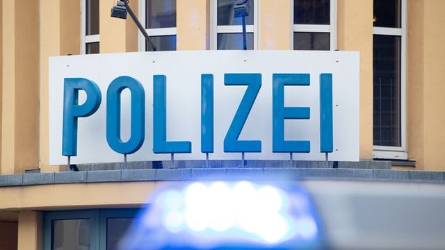 Ein Einsatzwagen der Polizei steht vor einer Dienststelle