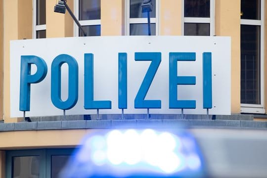 Ein Einsatzwagen der Polizei steht vor einer Dienststelle