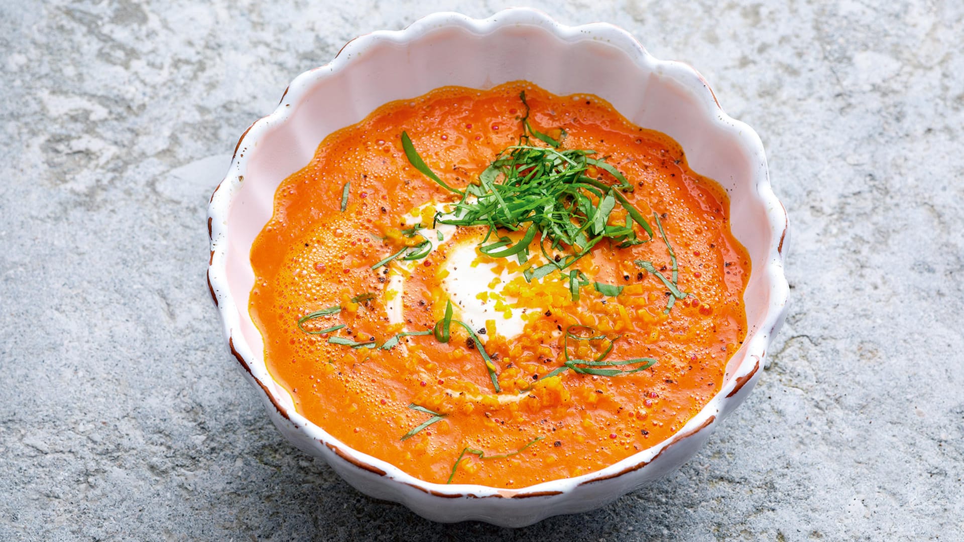 Tomatensuppe: Wer testen will, ob man den Kater mit Alkohol bekämpfen kann, macht in die schnelle Tomatensuppe einen Schuss Gin und toppt sie mit etwas Orangenschale.