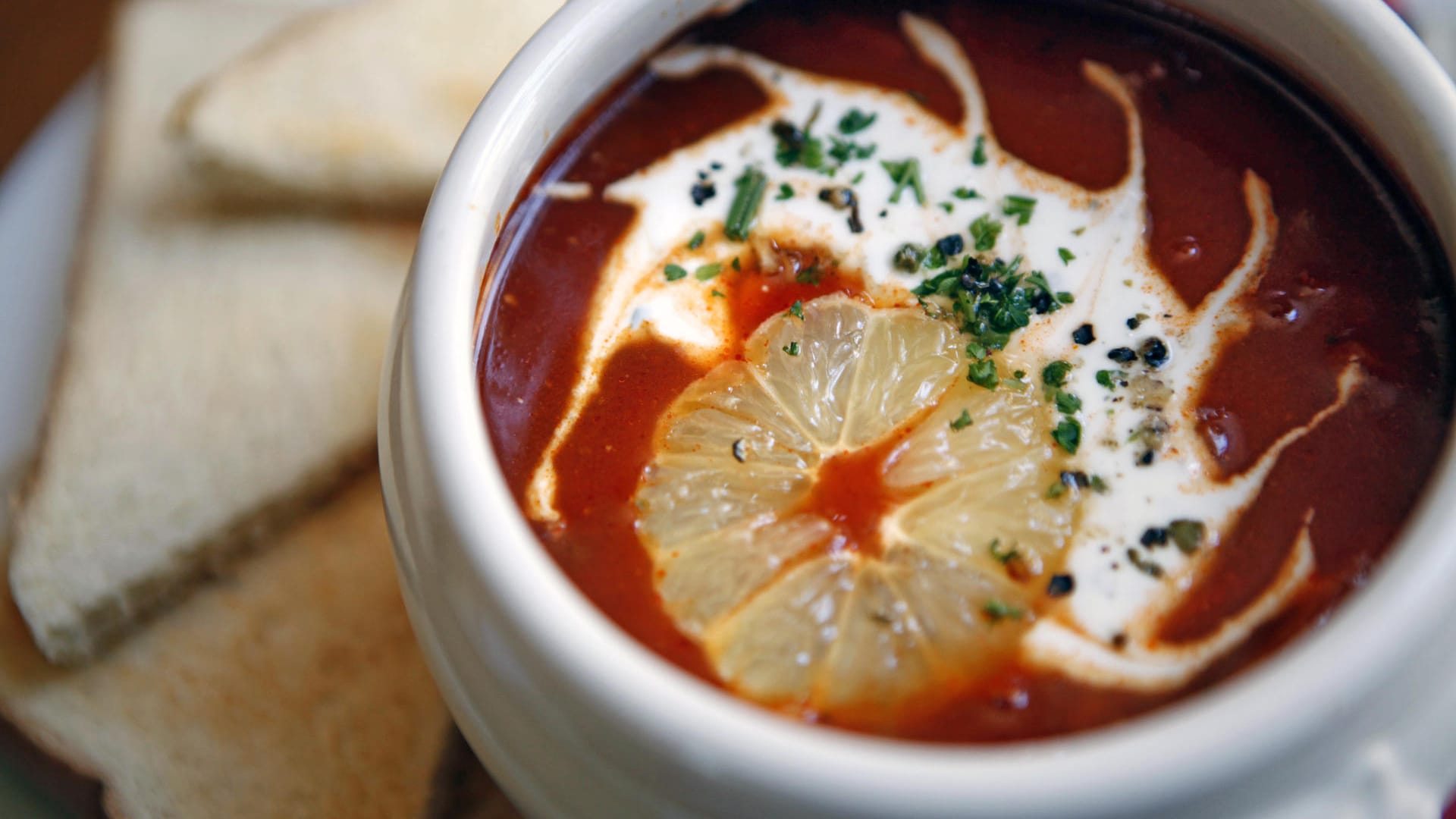 Soljanka: Die osteuropäische Wurstsuppe wird mit Paprika, sauren Gurken, Zwiebeln und einem großzügigen Klecks Schmand serviert.