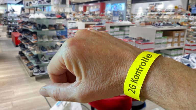 Eine Person trägt ein Bädchen mit Aufschrift "2G-Kontrolle" um den Arm (Symbolbild): So soll der Einzelhandel entlastet werden.