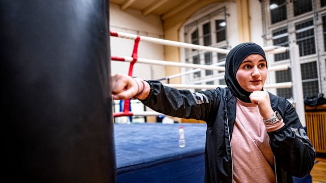 Boxtrainerin Doha Taha Beydoun steht in der Turnhalle beim Boxtraining. Boxtrainerin Doha Taha Beydoun steht in der Turnhalle beim Boxtraining.