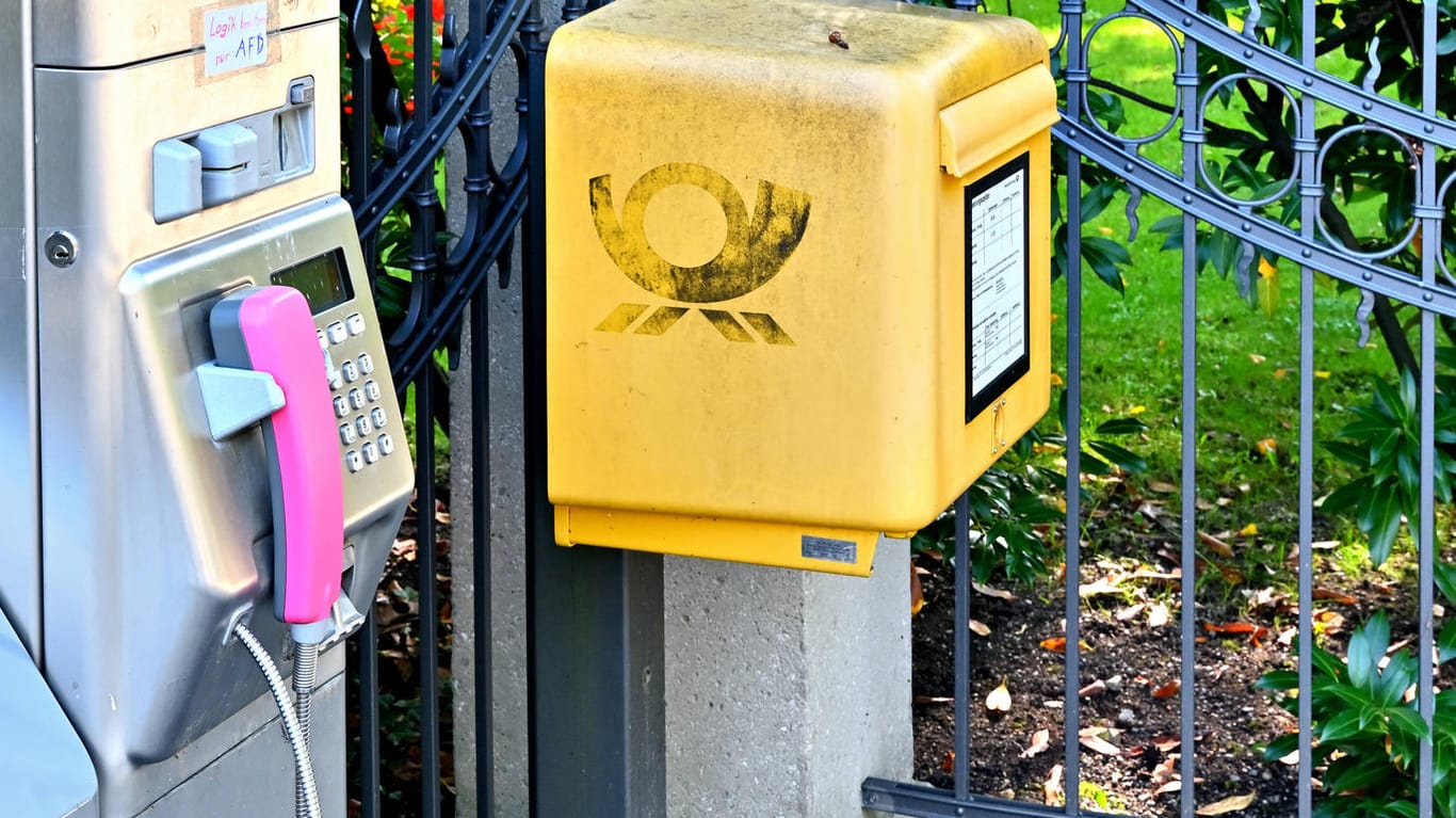 Ein Briefkasten steht neben einer Telefonsäule (Symbolbild): Das Porto wird im Januar teurer.