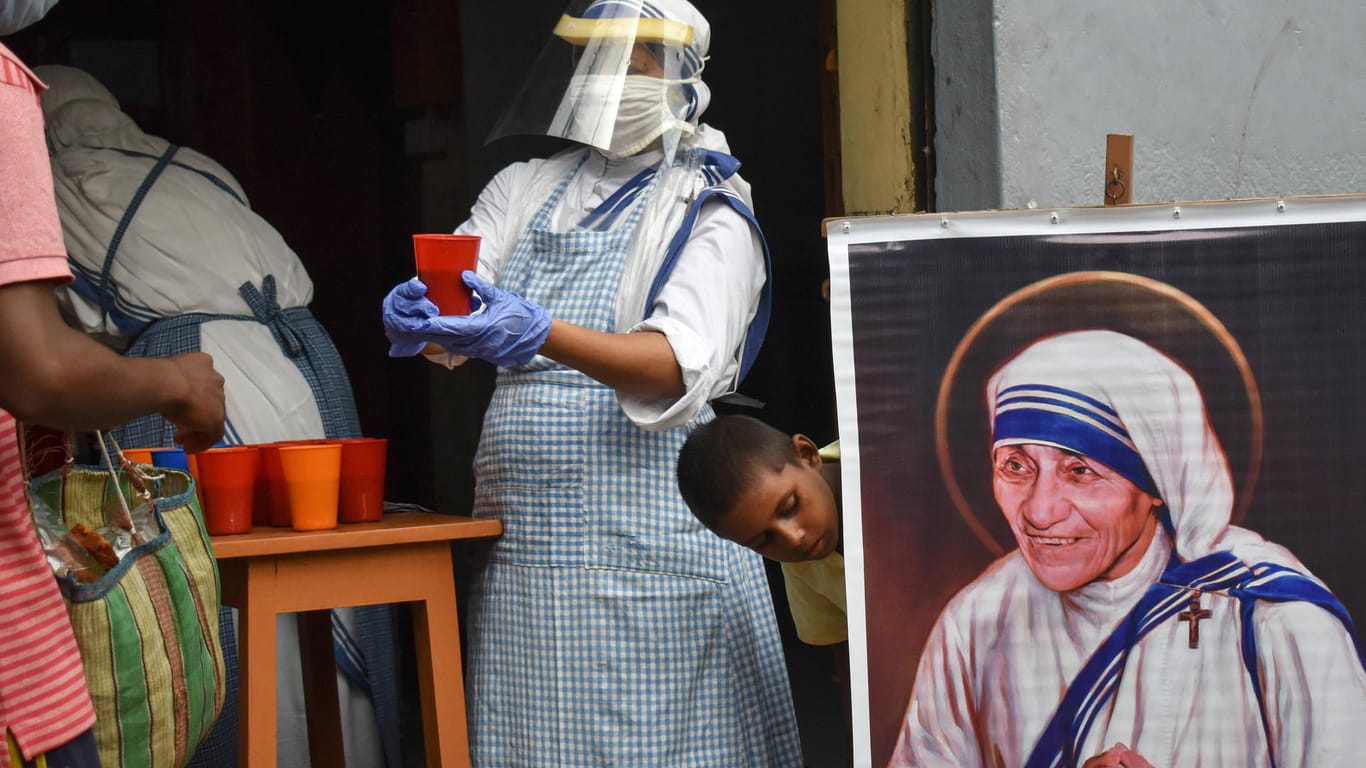 Eine Helferin von "Missionare der Wohltätigkeit" neben einem Bild von Mutter Teresa: Die Organisation soll keine ausländischen Gelder mehr annehmen dürfen.