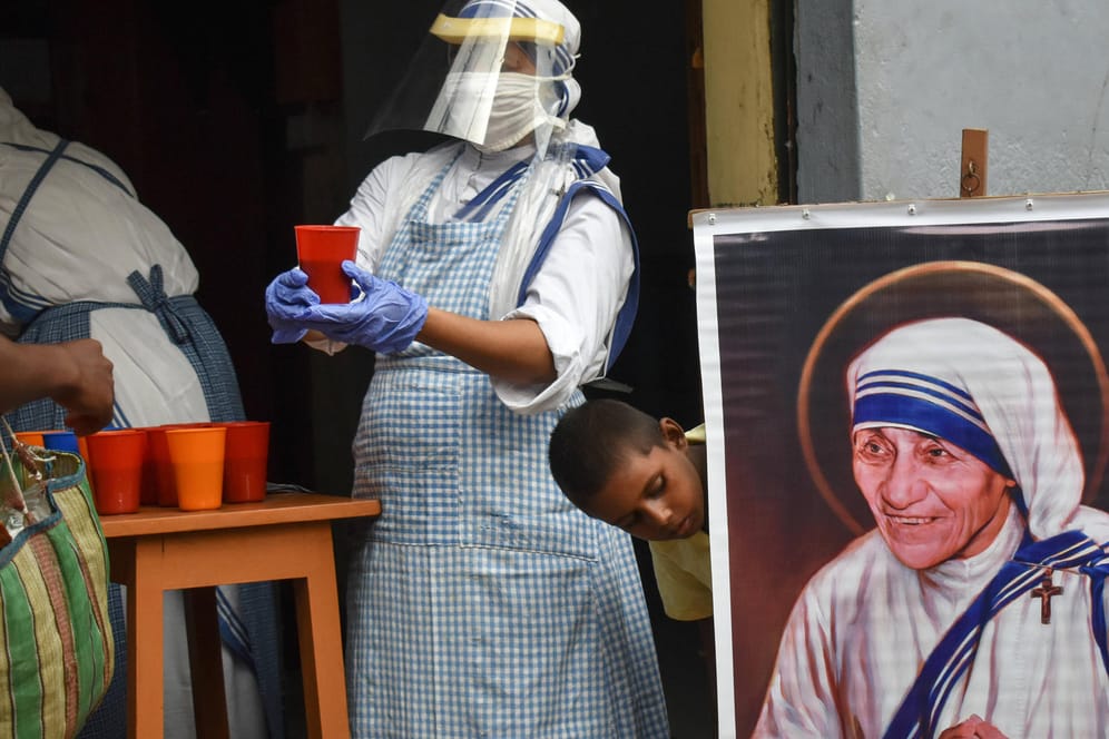 Eine Helferin von "Missionare der Wohltätigkeit" neben einem Bild von Mutter Teresa: Die Organisation soll keine ausländischen Gelder mehr annehmen dürfen.