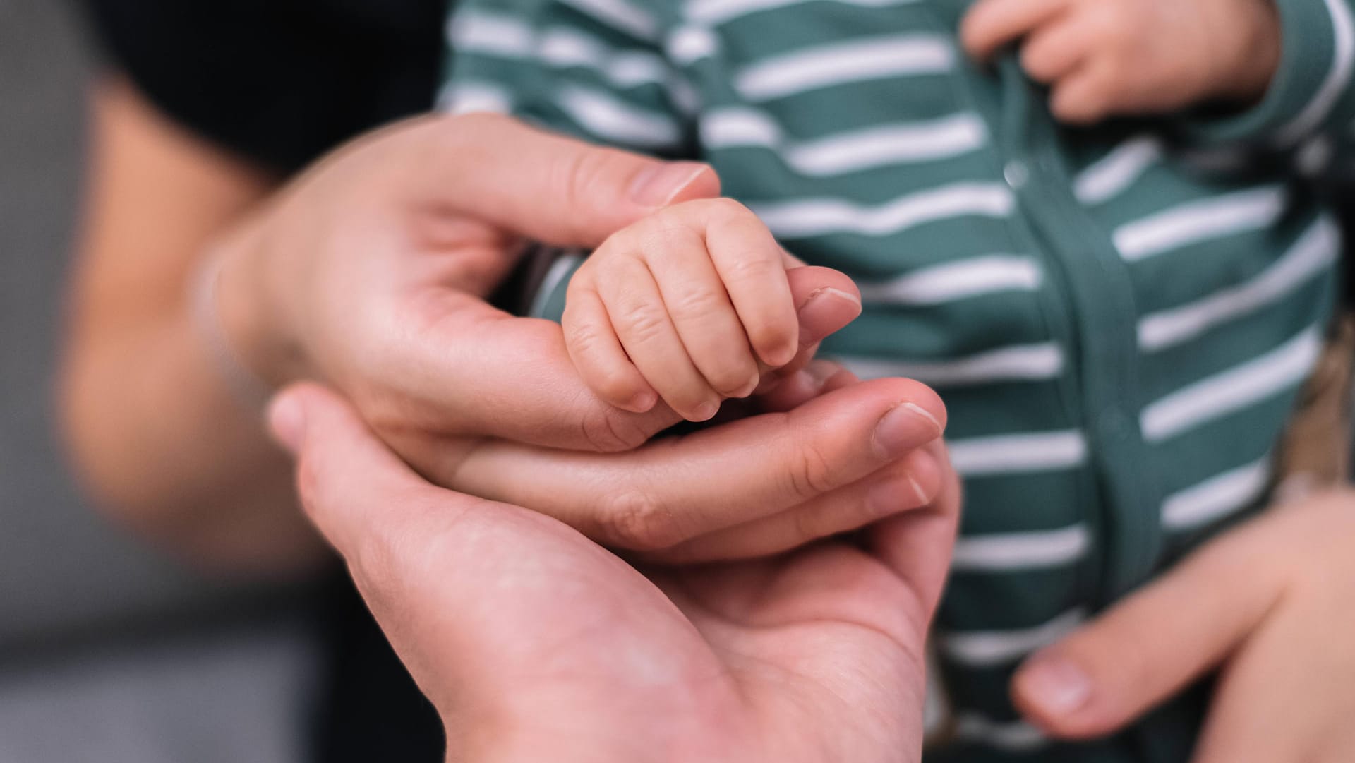 Eltern halten die Hand eines Babys (Symbolbild): Eine Person muss über weibliche Fortpflanzungsorgane verfügen.