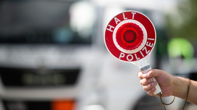 Eine Polizeikelle (Symbolbild): Der Lkw-Fahrer hielt unbeleuchtet auf dem Standstreifen.