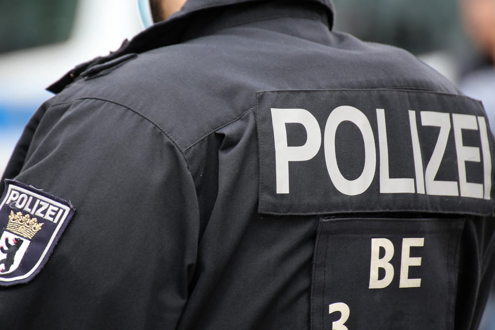 Wappen der Berliner Polizei auf dem Einsatzanzug eines Polizisten (Symbolbild): Der Polizist musste in einem Krankenhaus behandelt werden.