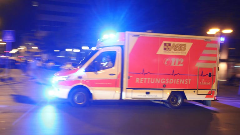 Rettungswagen des ASB fährt am Abend mit Blaulicht während eines Noteinsatzes in Frankfurt. (Symbolbild) Der 19-Jährige musste notoperiert werden.