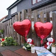Luftballons in Herzform, Plüschtiere, Kerzen und Blumen stehen vor dem Eingang zu einem Haus (Archivbild): Die Mutter hat als Einzige überlebt.