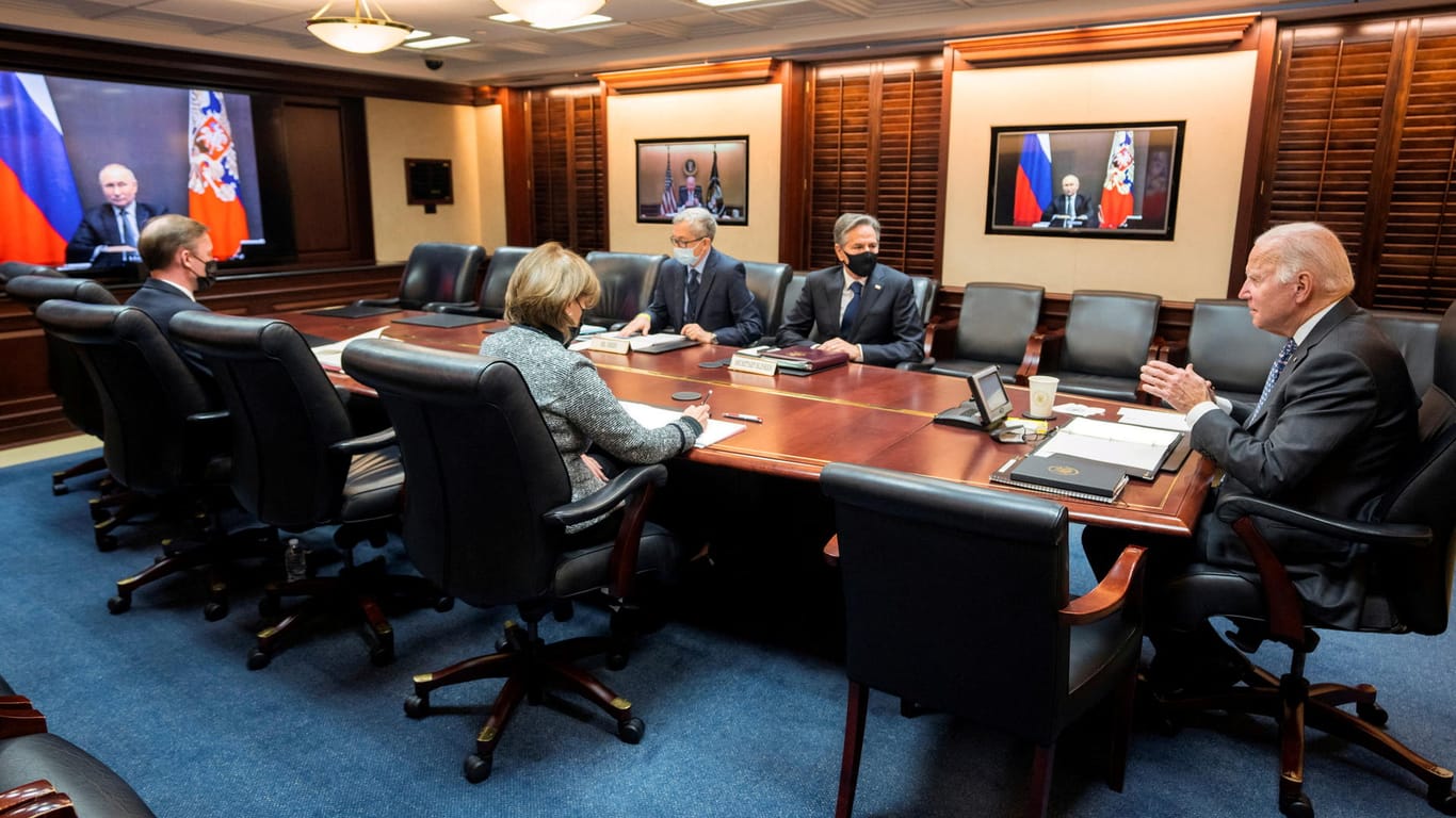 US-Präsident Joe Biden telefoniert über eine Videoschalte mit Wladimir Putin, US-Außenminister Anthony Blinken sitzt ebenfalls am Tisch (rechts).