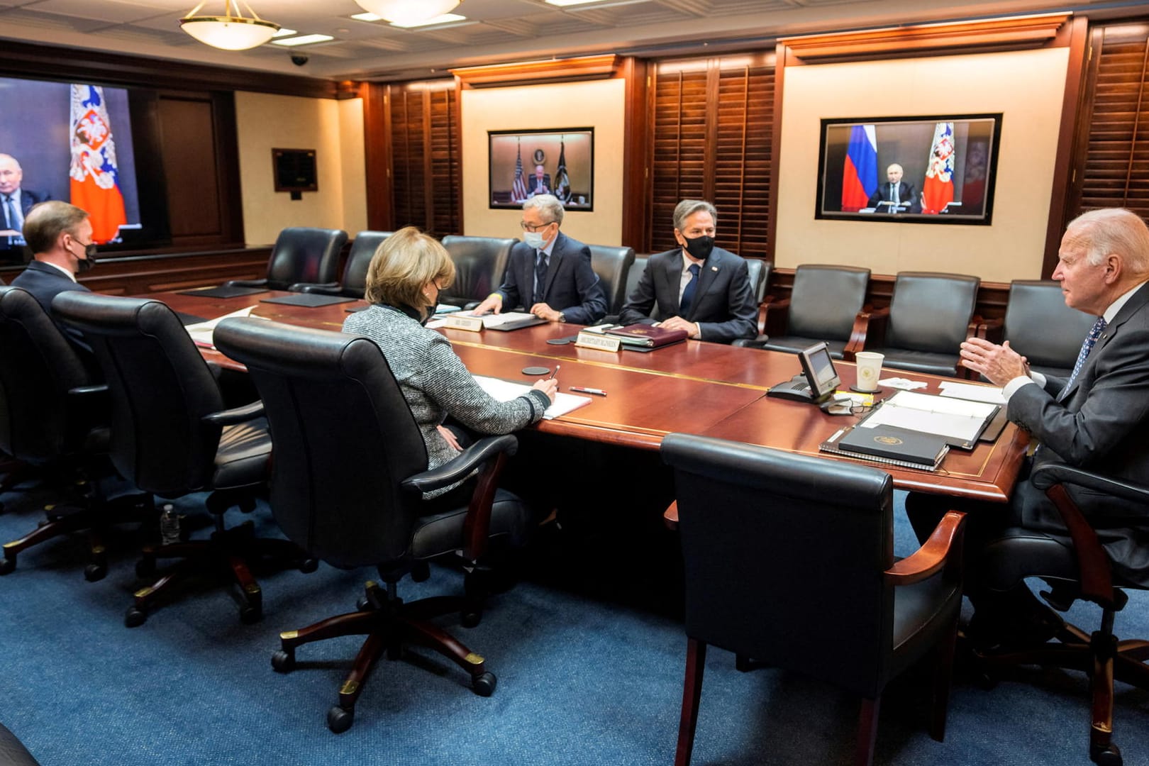 US-Präsident Joe Biden telefoniert über eine Videoschalte mit Wladimir Putin, US-Außenminister Anthony Blinken sitzt ebenfalls am Tisch (rechts).