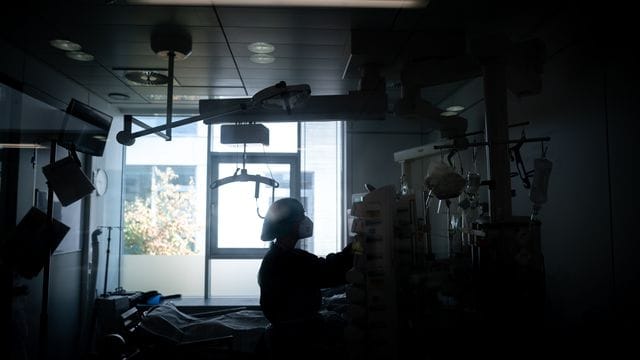 Eine Pflegekraft steht in einem Krankenzimmer Eine Pflegekraft steht in einem Krankenzimmer