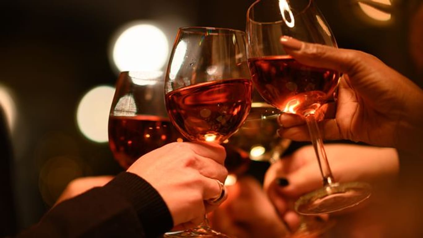 Gäste stoßen in einem Restaurant mit Weingläsern an