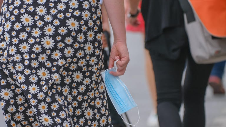 Eine Frau mit einer Schutzmaske (Symbolbild): Der bundesweite Inzidenzwert liegt bei 1176,8.