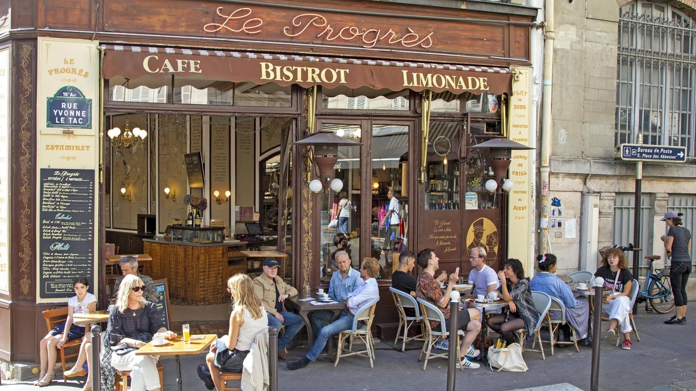 Ein Pariser Café im Sommer (Symbolbild): Neben den bekannten Sehenswürdigkeiten locken auch traditionelle Bistros, spannende Ausstellungen, bunte Märkte und zahlreiche Antiquitätenläden in die französische Hauptstadt.