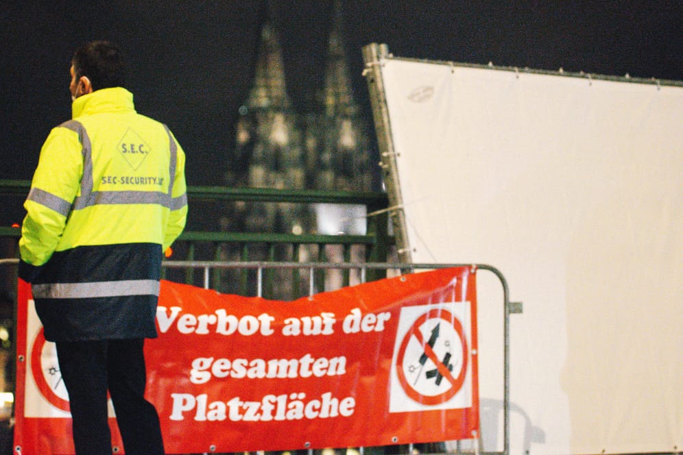 Ein Mitarbeiter eines Sicherheitsdienstes steht vor einer Böllerverbotszone am Rhein: Die Silvesternacht in Köln verlief weitgehend störungsfrei.