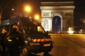 Polizisten vor dem Arc de Triomphe in Paris: Trotz vieler Einsatzkräfte brannten um den Jahreswechsel viele Autos in Frankreich.
