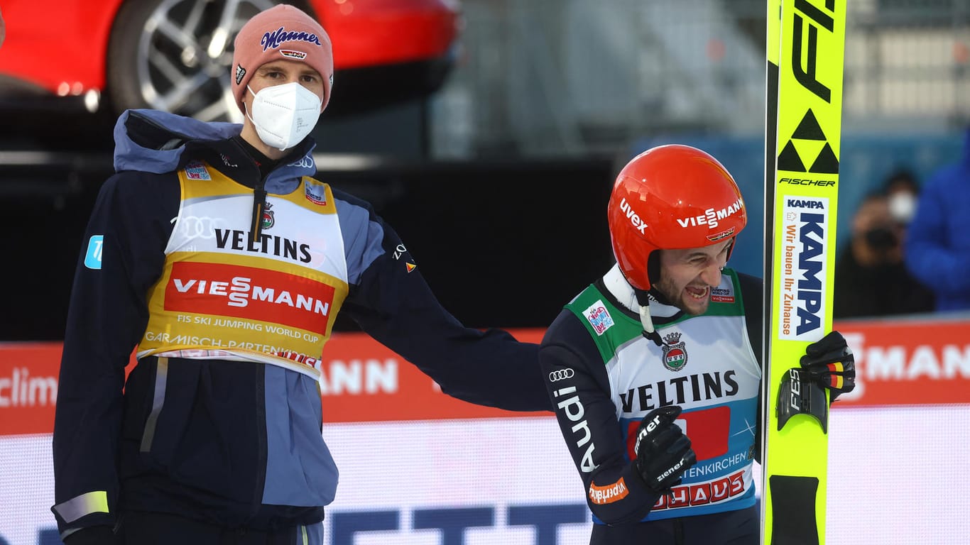 Bild mit Symbolcharakter: Während Markus Eisenbichler (r.) ausgelassen über seinen zweiten Platz in Garmisch-Partenkirchen jubelt, klopft ihm der sichtlich enttäuschte Karl Geiger auf die Schulter.