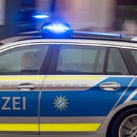 Ein Fahrzeug der bayerischen Polizei ist mit Blaulicht im Einsatz (Symbolbild): Die Polizei sucht nach dem Angreifer und seinen Begleitern.