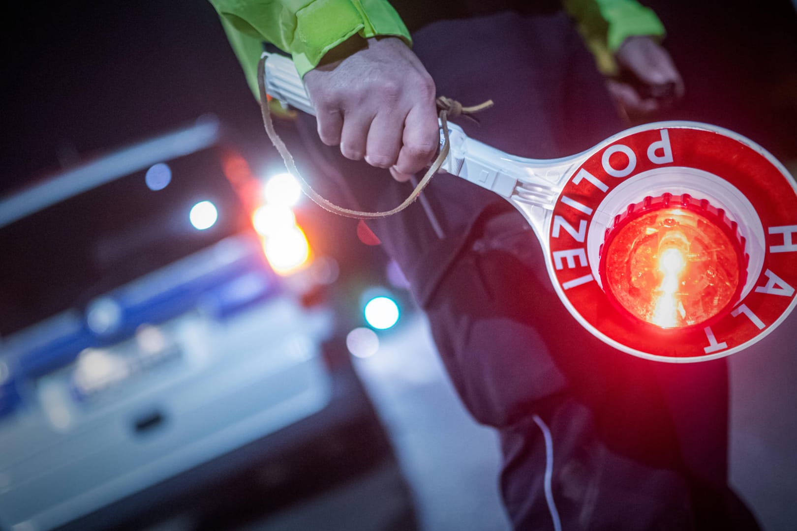 Ein Polizist hält eine Kelle mit dem Schriftzug "Stopp" in der Hand (Symbolbild): Eine mögliche Tatwaffe wurde bei einem alkoholisierten Autofahrer entdeckt.