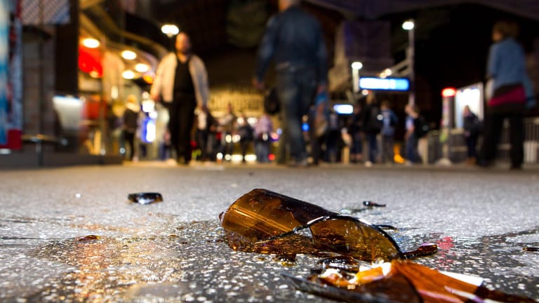 Eine zerbrochene Glasflasche liegt auf der Straße (Symbolbild): Mehrere Menschen mussten ins Krankenhaus gebracht werden.
