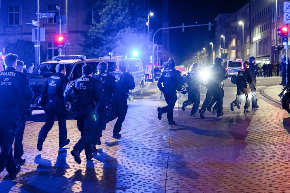 Eine Einheit der Polizei bereitet sich auf die Räumung eines Platzes in Schweinfurt vor und läuft über die Straße.