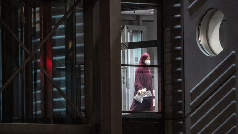 Eine verschleierte Frau mit Mund-Nasen-Bedeckung verlässt eine Chartermaschine und betritt einen abgeschirmten Bereich der Bundespolizei am Flughafen (Symbolbild).