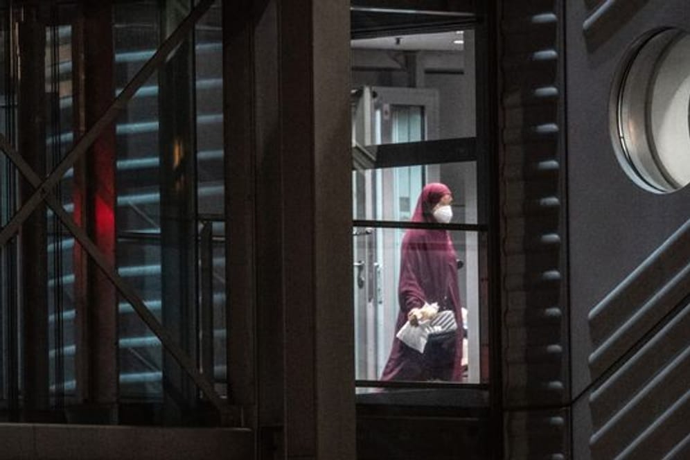 Eine verschleierte Frau mit Mund-Nasen-Bedeckung verlässt eine Chartermaschine und betritt einen abgeschirmten Bereich der Bundespolizei am Flughafen (Symbolbild).