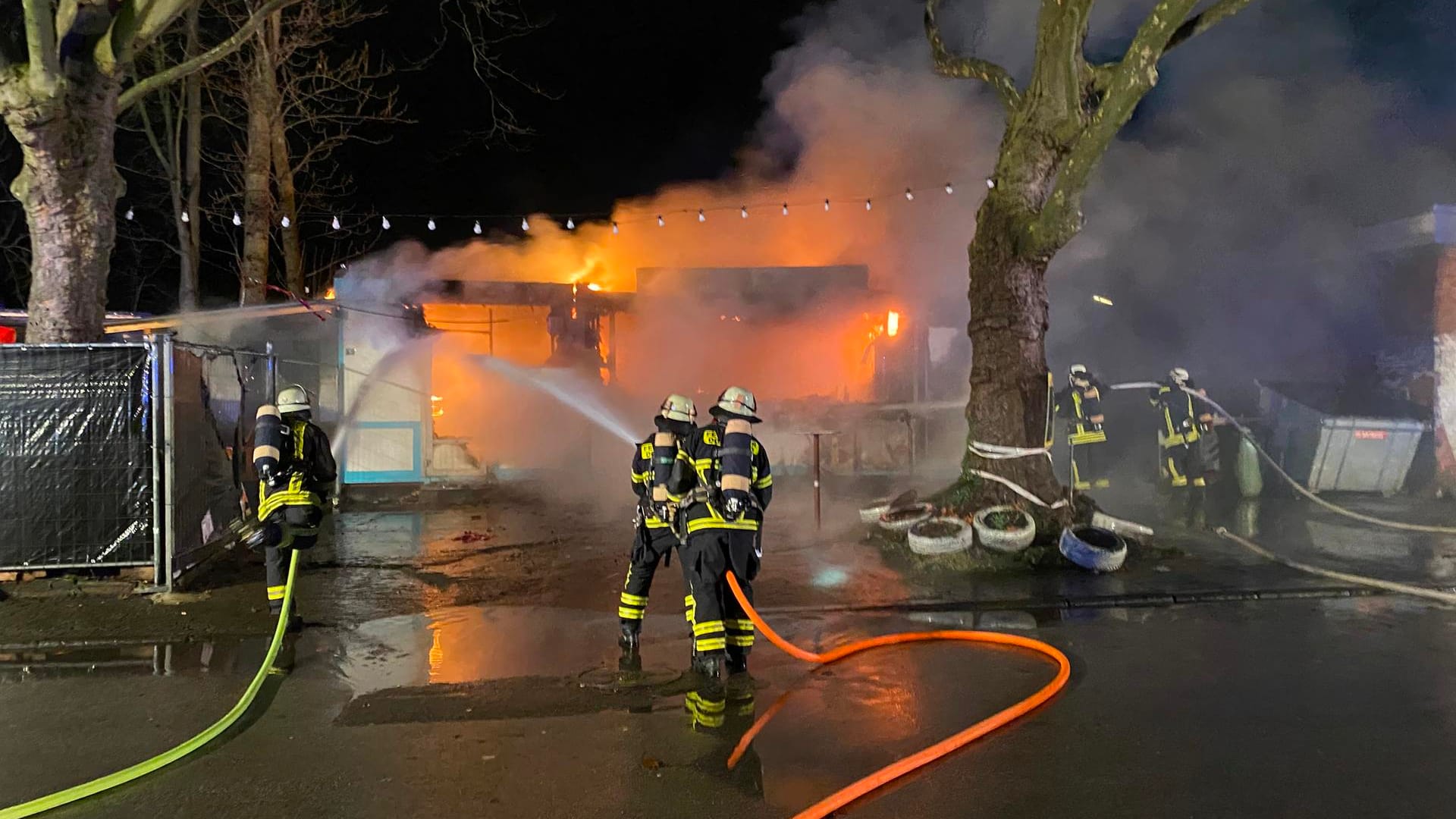 Einsatzkräfte vor dem brennenden Imbiss: Die Container sind vollkommen ausgebrannt. Einsatzkräfte vor dem brennenden Imbiss: Die Container sind vollkommen ausgebrannt.
