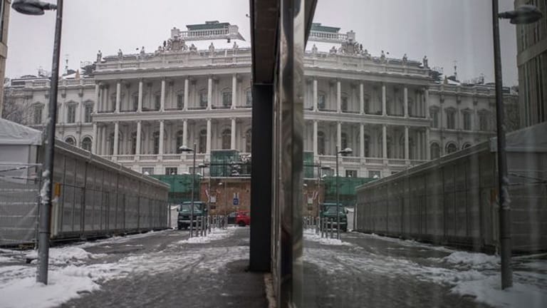 Das Palais Coburg in Wien spiegelt sich an einer Fensterfassade.