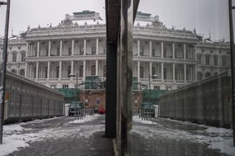 Das Palais Coburg in Wien spiegelt sich an einer Fensterfassade.