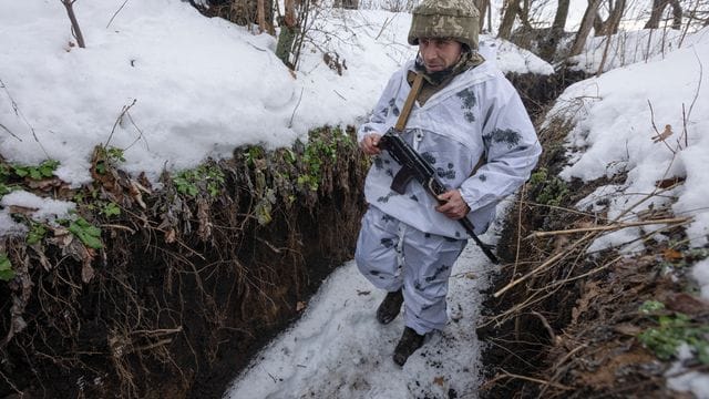 Ein ukrainischer Soldat geht an der Frontlinie zu prorussischen Rebellen in der Region Donezk in einem Schützengraben entlang.