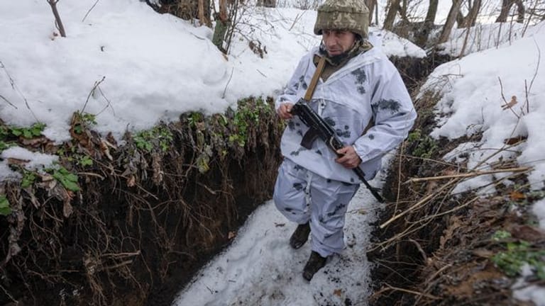 Ein ukrainischer Soldat geht an der Frontlinie zu prorussischen Rebellen in der Region Donezk in einem Schützengraben entlang.