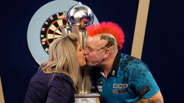 Peter Wright feiert mit seiner Frau Joanne und der Sid Waddell Trophy seinen Sieg.