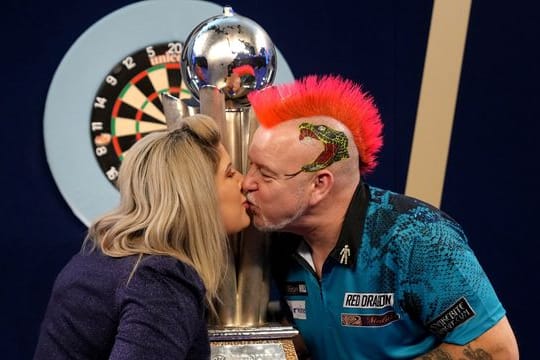 Peter Wright feiert mit seiner Frau Joanne und der Sid Waddell Trophy seinen Sieg.