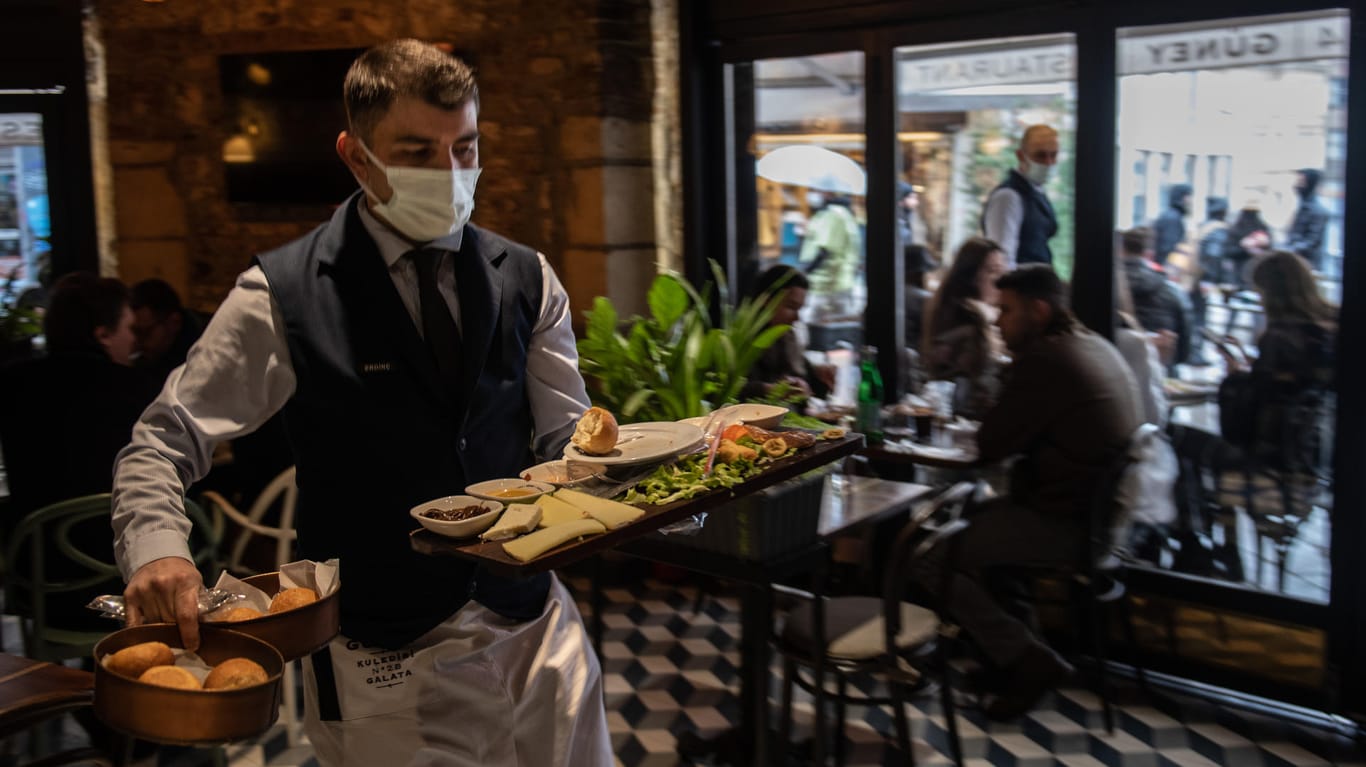 Kellner mit Maske (Symbolbild): Gerade im Gastronomiegewerbe hat die Zahl der Kurzarbeiter im Dezember wieder zugenommen.