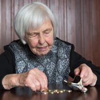 Ältere Frau zählt Münzen (Symbolbild): Eine Auswertung der Rentenversicherung zeigt, wie stark die Renten in den vergangenen Jahren im Vergleich zur Inflation gestiegen sind.