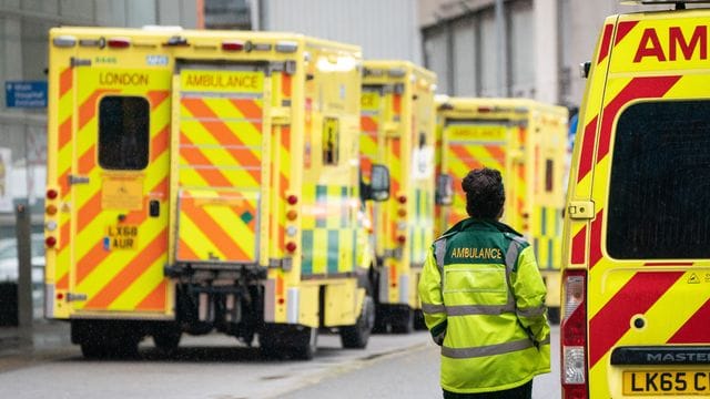 Eine Rettungssanitäterin geht an einer Reihe Krankenwagen vor einem Londoner Krankenhaus vorbei.
