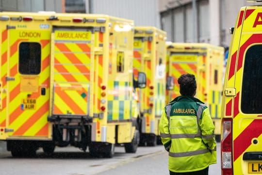 Eine Rettungssanitäterin geht an einer Reihe Krankenwagen vor einem Londoner Krankenhaus vorbei.