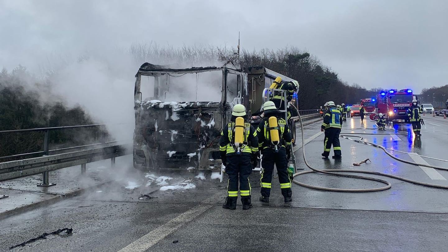 Feuerwehrleute stehen vor dem ausgebrannten Fahrzeug: Wie es zu dem Feuer kam, ist derzeit noch unklar. Feuerwehrleute stehen vor dem ausgebrannten Fahrzeug: Wie es zu dem Feuer kam, ist derzeit noch unklar.