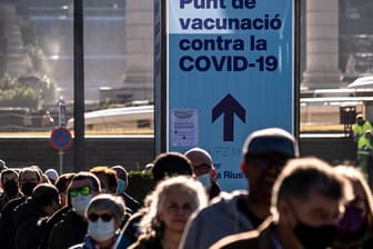 Zahlreiche Menschen stehen in Barcelona Schlage vor einer Impfstelle.