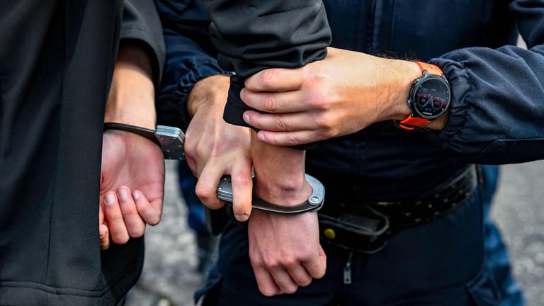 Polizist legt einer Person Handschellen an (Symbolbild): Der Verdächtige soll zwei Mädchen in Böblingen und Stuttgart missbraucht haben.
