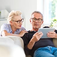 Mann und Frau mit Tablet: Ein Selbsttest im Internet ermöglicht eine ungefähre Einschätzung des eigenen Herzinfarktrisikos.