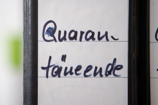 Ordner mit der Aufschrift "Quarantäneende" stehen in einem Gesundheitsamt.