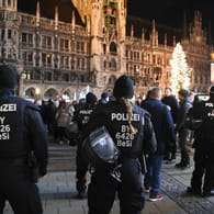 Polizisten stehen auf dem Marienplatz: Die Polizei in Bayern ist in zahlreichen Kommunen für unangemeldete "Spaziergänge" und Zusammenkünfte von Gegnern der staatlichen Corona-Maßnahmen vor Ort.