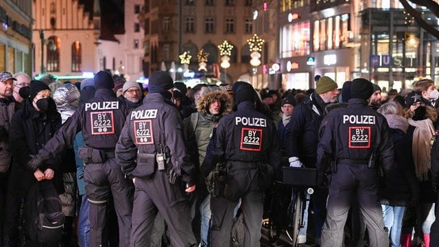 Polizisten kontrollieren Passanten in der Fußgängerzone.